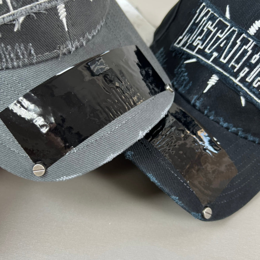 Black distressed cotton cap with metal graphic and glossy shield brim